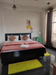 - une chambre avec un grand lit et des tapis jaunes dans l'établissement Hill Veu Home Bir Billing, à Bir