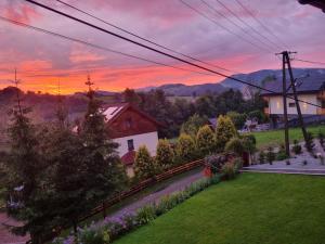 a sunset over a yard with a house and flowers at sunset view house in Stryszawa