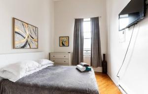 una camera da letto con un letto e una televisione di Majestic 3 Bedroom Apartment in NYC! a New York