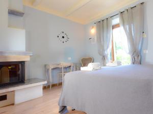 Habitación blanca con cama y ventana en Agriturismo Le Casaline, en Seggiano