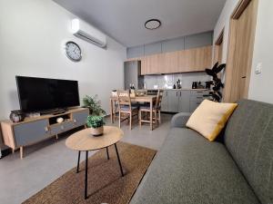 un soggiorno con divano e tavolo e una cucina di modern apt near Heraklion city & airport a Néa Alikarnassós