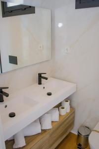 Baño blanco con lavabo y espejo en Bungalows Mar Menor, paz a orillas del mar, en San Javier