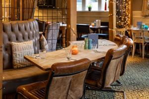 una mesa de madera y sillas en un restaurante en The Devonshire Arms en Baslow