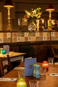 una mesa en un restaurante con un jarrón de flores en The Devonshire Arms en Baslow