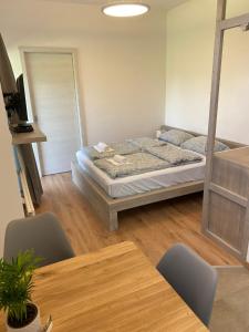 - une chambre avec un lit et une table avec des chaises dans l'établissement Apartment Nona Polda, à Kobarid