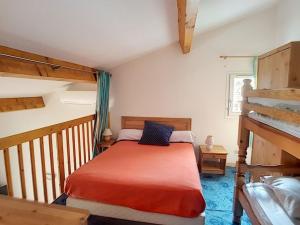 una camera con un letto rosso e un letto a castello di Pavillon T2 avec grande terrasse a Narbonne-Plage