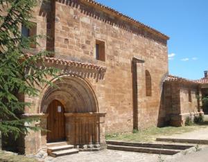 San Millán de Lara的住宿－San Pelayo，一座带木门的旧砖砌建筑