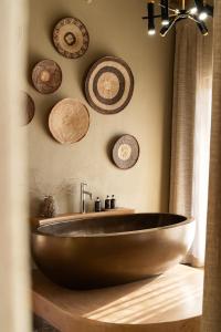 uma casa de banho com um lavatório de madeira e placas na parede em Sandfontein Lodge & Nature Reserve em Sandfontein