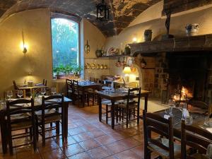 ムリエスにあるChâteau de Servanesのテーブルと椅子、暖炉のあるレストラン