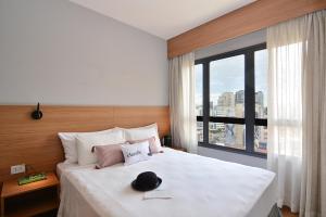 una camera d'albergo con un letto con un cappello sopra di Charlie Faria Lima a San Paolo