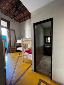 Parla Hostel في بوينس آيرس: باب مفتوح لغرفة بها سرير بطابقين