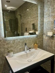 a bathroom with a sink and a large mirror at Quite Simply French in Lancaster