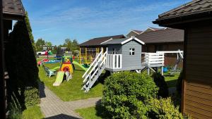 un parque infantil con juegos y una casa en Domki Maciejka, en Dąbki