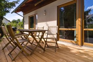 a wooden deck with a table and two chairs at Ferienhaus am Mühlbach Ammersee in Utting am Ammersee