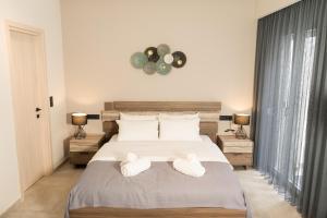 a bedroom with a large bed with towels on it at Lorien City Center Apartments in Ioannina