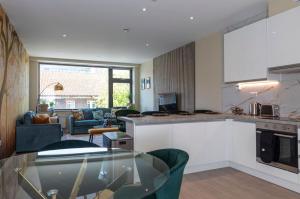 a kitchen and living room with a glass table at Palm Tree House - Birds of Feather in Orpington