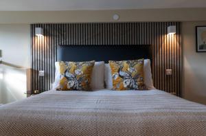 a bedroom with a large bed with a wooden headboard at Palm Tree House - Birds of Feather in Orpington