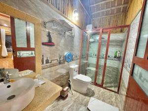 y baño con aseo, lavabo y ducha. en Tam Coc Eco Field Homes, en Ninh Binh