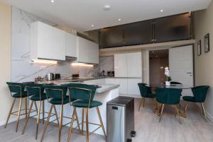 a kitchen with green bar stools and a counter at Palm Tree House - Birds of Feather in Orpington