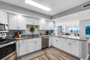 a large white kitchen with white cabinets and appliances at Beachfront Oasis at Litchfield By the Sea: 3 Bdrm in Pawleys Island