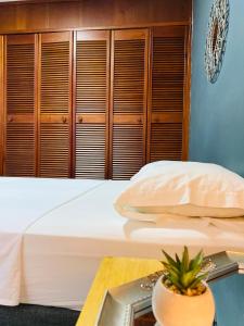 um quarto com uma cama branca e armários de madeira em Casa compartida ''Central Hostel'' em Medellín