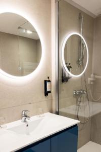 a bathroom with a sink and a shower with a mirror at Royal Antibes - Luxury Hotel, Résidence, Beach & Spa in Antibes