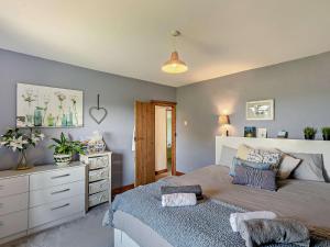 een slaapkamer met een groot bed en een dressoir bij 3 Bed in Lydbrook 94490 in Lydbrook