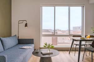 a living room with a blue couch and a table at Sonder The Sloan in Philadelphia