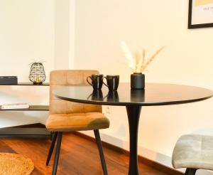 a dining room table and a chair with a table at MILPAU Buer 3 - Modernes und zentrales Premium-Apartment mit Queensize-Bett, Netflix, Nespresso und Smart-TV in Gelsenkirchen