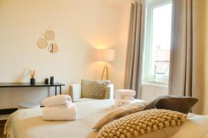 een slaapkamer met een bed met een stoel en een raam bij MILPAU Buer 3 - Modernes und zentrales Premium-Apartment mit Queensize-Bett, Netflix, Nespresso und Smart-TV in Gelsenkirchen