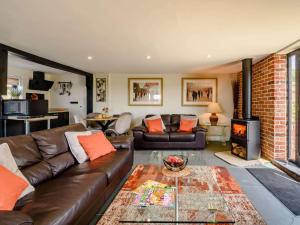 a living room with a leather couch and a fireplace at 1 Bed in Sissinghurst 88466 