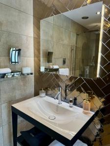 a bathroom with a sink and a large mirror at Quite Simply French in Lancaster