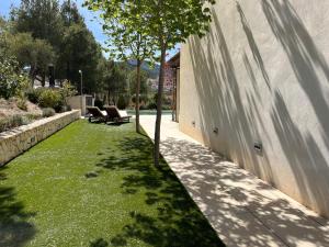 une cour avec de l'herbe verte à côté d'un bâtiment dans l'établissement Villa Aldora. Villa con piscina en Moratalla, à Moratalla