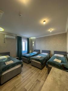 ein Hotelzimmer mit drei Betten in der Unterkunft Сарканд in Proletarskiy