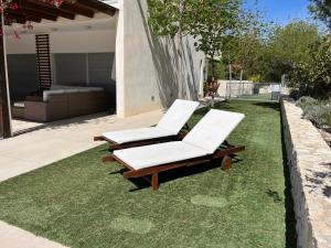 deux chaises longues sur l'herbe dans un jardin dans l'établissement Villa Aldora. Villa con piscina en Moratalla, à Moratalla