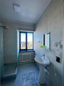 ein Badezimmer mit Waschbecken und Dusche in der Unterkunft Сарканд in Proletarskiy