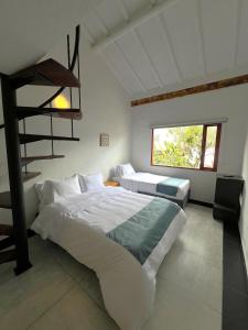 a bedroom with two beds and a ladder at Hotel Antiguo Macondo in Villa de Leyva