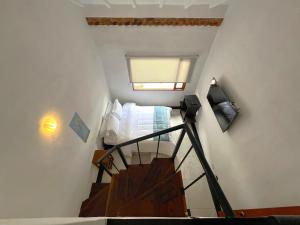 a small bedroom with a bed and a staircase at Hotel Antiguo Macondo in Villa de Leyva