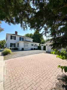 a brick driveway in front of a white house at Beautiful Historic Luxury Getaway in Niagara-on-the-Lake +55 photos