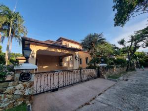 a house with a fence and palm trees at Nusa chivani pool villa najomtien with 4 bedrooms ณุศา ชิวานี พลูวิลล่า 4 ห้องนอน นาจอมเทียน in Na Jomtien