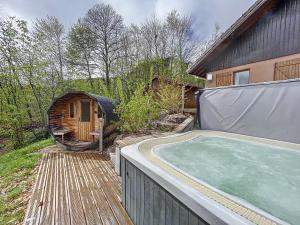 a backyard with a hot tub and a house at Chalet de standing 14 personnes in Gérardmer