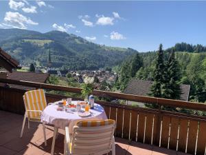 a table and chairs on a balcony with a view at Ferienwohnung am Letzberg in Schönau im Schwarzwald