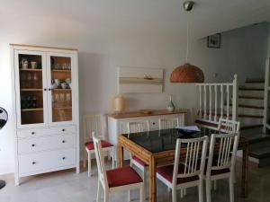 cocina con mesa de comedor y sillas en Casa adosada Marina playa y golf, en San Luis de Sabinillas