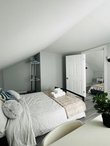 Habitación blanca con cama y espejo en Two story house with backyard, en Peterborough