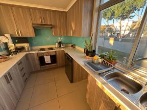 a kitchen with a sink and a large window at Tyger Valley Villa in Durbanville