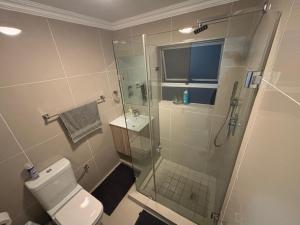 a bathroom with a shower and a toilet and a sink at Tyger Valley Villa in Durbanville