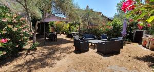 un patio con mesa y sillas en un jardín en Meublés de Tourisme Casa Erbaggio, en Sartène