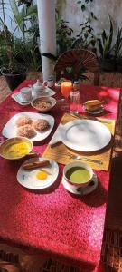 uma mesa com pratos de comida numa toalha de mesa vermelha em Leisure home em Colombo