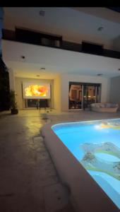 a large swimming pool in a house with a painting on the wall at Sunluxvilla ,Heated Pool, IR Sauna in Kaštela