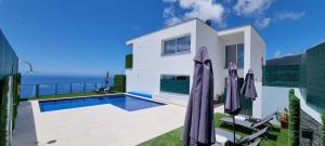 a villa with a swimming pool and the ocean at Casa Mar Azul in Arco da Calheta